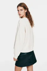 Buzo de corte oversized con cuello redondo, mangas largas de hombros caídos y puños acanalados. Presenta un diseño estampado frontal con la inscripción Florence Renaissance y un motivo floral central.