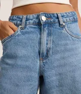 Bermuda de cintura mediana confeccionada en jean, con trabillas en la cintura, cierre tradicional, bolsillos y bajo deshilachado.