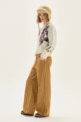 Jean de corte wide leg y tiro medio, con diseño de rayas verticales en tonos amarillo y marrón.