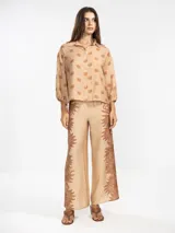 Pantalón palazzo negro con estampado de sirenas en color beige.