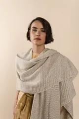 Ruana de lana fina sin teñir, con diseño de tejido texturizado y terminaciones hechas a mano en crochet.