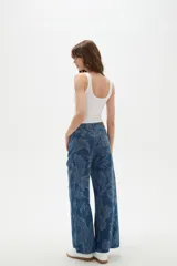 Pantalon de jean de tiro alto con corte ancho y estampado floral en tonos azules. Cuenta con bolsillos laterales y traseros.