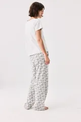 Pijama de algodón gris melange con estampado de gatos, compuesto por una remera de manga corta con cuello redondo y un pantalón largo de corte recto con cintura elástica.
