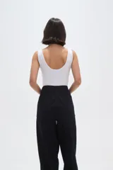 Body de poliamida al cuerpo con breteles anchos, cuello profundo y cierre con broches en la parte inferior.