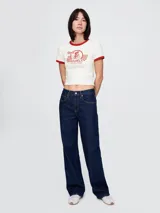 Remera corta color crudo con cuello y mangas con ribete rojo. Estampado frontal con un ciclista y texto "Brooklyn Cycling".