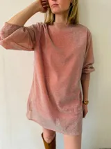 Vestido corto de lurex color salmón con brillo, escote redondo y mangas largas abullonadas. Incluye lazo para marcar la cintura.