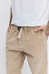 Pantalon de corte recto confeccionado en pana color beige, con cintura elástica y cordón ajustable.