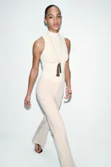 Pantalón de vestir color rosado, tiro bajo, con corte acampanado (flare) y costuras laterales marcadas. Cierre frontal con botón interior y gancho.