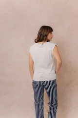 Remera de algodón color crema, con cuello redondo y mangas cortas con dobladillo vuelto. Presenta un corte relajado y estructura en los hombros.