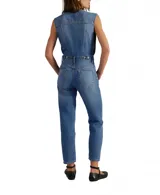 Overol de denim azul, sin mangas, con cuello camisero y cierre frontal. El pantalón es de corte chupín ajustado al cuerpo.