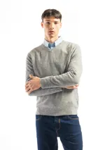 Buzo de punto con cuello en V, manga larga y puños acanalados. Presenta un diseño clásico y versátil, confeccionado en tejido suave al tacto.