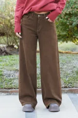 Jean de corte wide leg en color marrón, con tiro medio-alto y costuras a contratono. Presenta diseño de cinco bolsillos y cierre frontal con botón y cremallera.