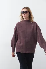 Polera gris de tejido suave de punto, con cuello alto, mangas abullonadas, puños elásticos y diseño relajado.