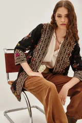 Kimono negro de algodón con bordados étnicos multicolores en el frente, mangas y ruedo. Posee un diseño abierto y mangas tres cuartos.