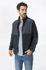 Campera de polar con cierre frontal completo, cuello alto y bolsillo en el pecho con cierre. Presenta un diseño combinado con paneles de tela técnica en la parte superior y polar en el resto de la prenda, con logo de la marca Benson & Thomas estampado en el hombro.