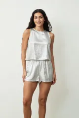Blusa plateada sin mangas con textura brillante.