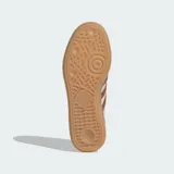 Championes Adidas Handball Spezial de diseño clásico, confeccionados en gamuza color beige con las icónicas tres tiras y refuerzo en el talón con textura de piel de serpiente en tono marrón. Presentan suela de goma color caramelo y detalles dorados en el lateral y la lengüeta.