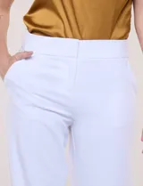 Pantalón sastrero blanco de tiro alto, corte wide leg y pierna ancha con caída fluida. Cuenta con cintura ancha lisa, cierre frontal oculto y bolsillos laterales.