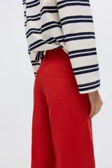 Pantalón en lona de algodón con cintura de tiro alto y cierre con botones. Piernas rectas con raya adelante y atrás, y bolsillos atrás de parche.