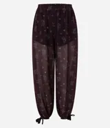 Pantalón largo estilo Aladino de Blue Steel, confeccionado en chiffon con estampado floral y detalles de encaje aplicado. Cuenta con cintura elástica y bajos ajustables con amarras en los tobillos.