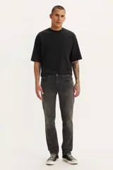 Pantalón de jean corte slim fit, color gris oscuro con efecto lavado, de tiro medio y cierre frontal con botón y cremallera.