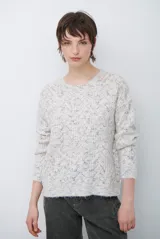 Buzo de tejido de punto con cuello redondo, mangas largas y textura jaspeada en tonos neutros.