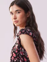 Conjunto de pijama de short y remera en tejido soft estampado. Remera de escote en V con aplique de puntilla, botones y detalle plisado. Short con cintura elastizada.