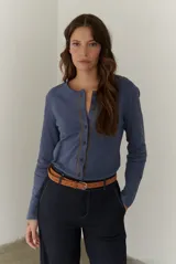 Cardigan de algodón en color azul, con cuello redondo, manga larga y cierre frontal con botones. Presenta costuras decorativas en contraste a lo largo de la botonera.