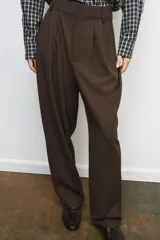 Pantalón de tiro medio confeccionado en mezcla con lana. Presenta diseño de corte recto con detalle de pinzas en el delantero, trabillas en la cintura y bolsillos laterales. Cierre frontal con cremallera, botón y ganchos metálicos.