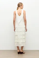 Maxi vestido crudo sin mangas con múltiples volados horizontales escalonados y escote redondo.