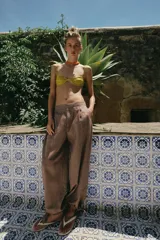 Sandalias planas tipo ojota de color beige, con tira delantera acolchada con separación para el dedo y suela fina.
