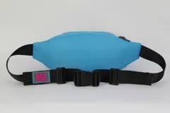 Riñonera celeste de nylon con contorno fucsia, cierre doble y correa regulable negra. Estampado frontal con el nombre "Miami" en cursiva y el logo de la NBA.