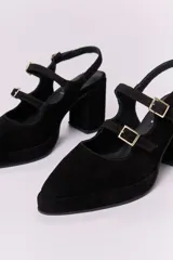 Zapatos de tacón tipo Mary Jane en gamuza color marrón, con doble tira con hebillas metálicas doradas sobre el empeine, punta cuadrada y taco bloque alto.