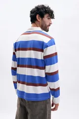 Remera de manga larga tipo polo con cuello camisero y cierre frontal de botones. Presenta un diseño de rayas horizontales anchas en tonos azul, blanco y marrón.