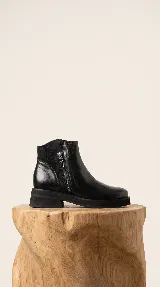 Bota corta de cuero negro con cierre lateral y taco cuadrado de 4 cm. Presenta un diseño minimalista con panel de gamuza en la parte posterior y suela de goma resistente.