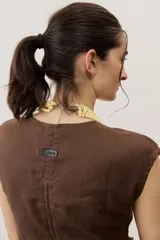 Remera marrón sin mangas, de corte recto y escote redondo.