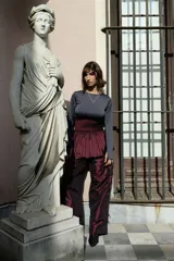 Minifalda negra de tafeta con cintura alta elastizada, diseño con volado y lazos laterales ajustables.