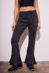 Pantalón de jean negro con corte flare, tiro medio y ruedo desflecado.