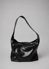 Cartera de cuero negro tipo slouchy, de diseño blando con asa larga para el hombro.