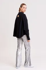 Pantalón de lentejuelas plateadas, corte acampanado.