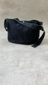 Bolso bandolera de tela denim celeste con correa ajustable.