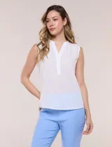 Blusa de gasa sin mangas de calce holgado, marca Sioni. Cuenta con cuello cadete, abertura frontal en V con media cartera de botones, espalda con canesú y pliegue central, y ruedo redondeado.