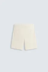 Bermuda de hombre color beige claro, corte regular fit, con pliegues frontales, bolsillos delanteros y bolsillos traseros de doble vivo con botón.