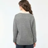 Sweater de punto grueso en color gris, con cuello redondo, mangas largas y corte holgado.