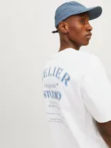 Camiseta blanca de algodón con cuello redondo y corte holgado. Estampado frontal con la leyenda "Atelier Originals Studio The Five Boroughs Established in Nineteen Ninety Designed in Copenhagen Brought to you by Jack & Jones".