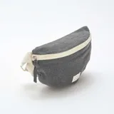 Riñonera gris de tela con cierre color crema y correa de algodón color crudo.