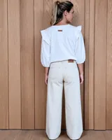 Jean de corte ancho y tiro medio, confeccionado en denim 100% algodón. Presenta costuras verticales decorativas en el frente y ruedo desflecado.