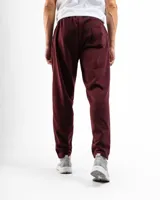 Pantalón de felpa color bordó, de corte slim y tiro medio, con puños ajustados en los tobillos.