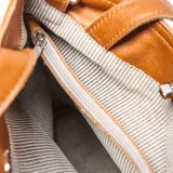 Cartera tipo bandolera grande de cuero color suela, con doble asa de mano y correa larga ajustable y extraíble. Presenta cierre superior con broche giratorio metálico y logo de la marca grabado en el frente.