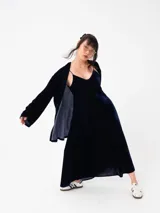 Kimono largo de terciopelo negro, con mangas largas y diseño abierto. Confeccionado en una mezcla de viscosa y poliamida, ofrece una caída fluida y elegante.